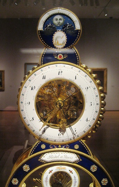 An old, intricately designed clock in an art museum