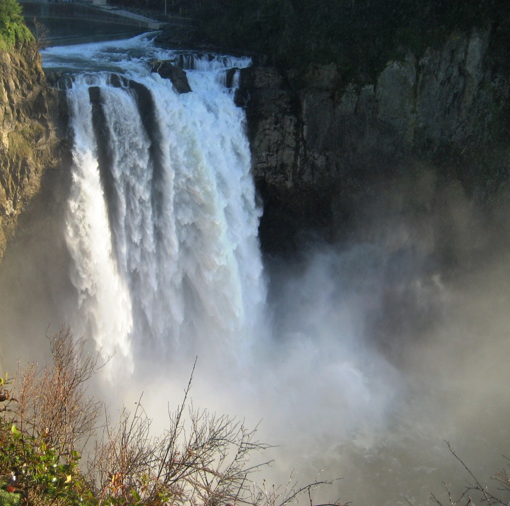 Snoqualmie Falls with the sun shining on it and the rising mist.
