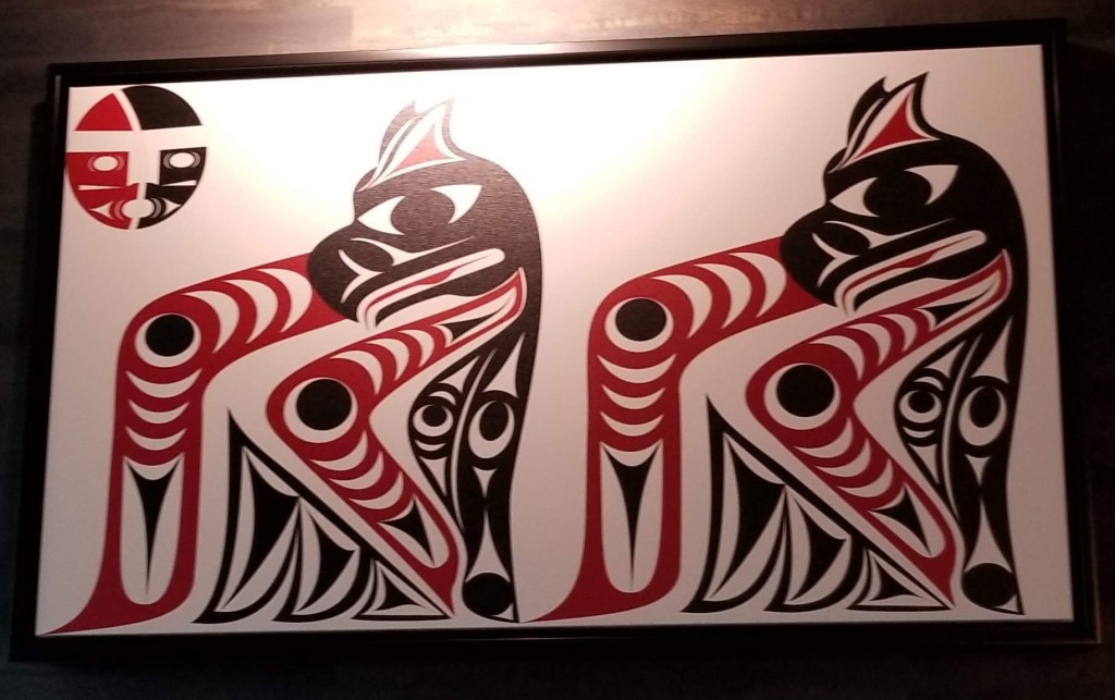 Salish artwork in red and black on white background - a red and black Salish Moon in the upper left corner.