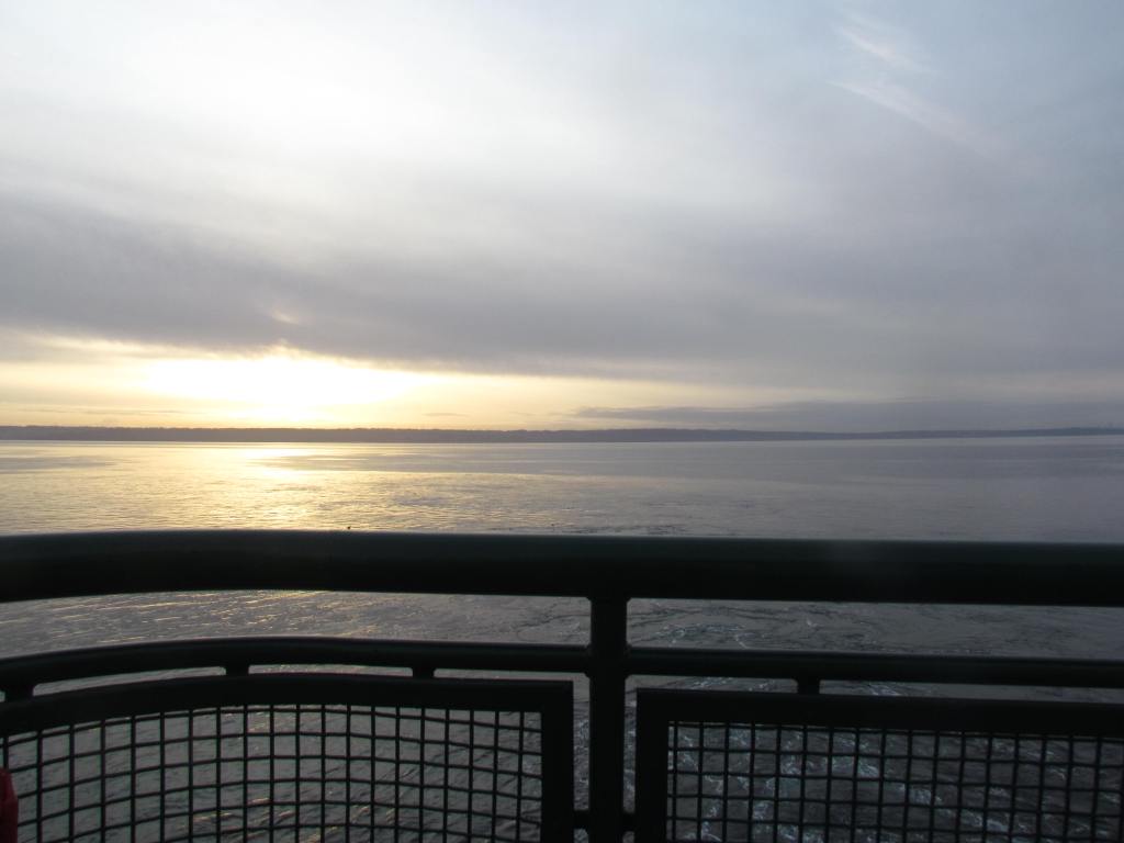Looking from the ferry out onto the water as the sun is fading in the clouds