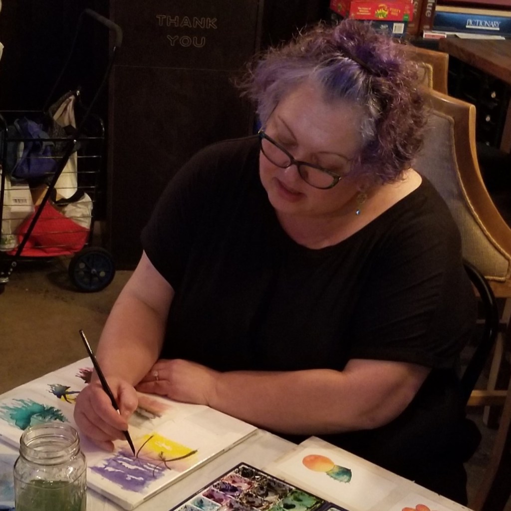 A woman demonstrating painting a scene over a watercolor sunset