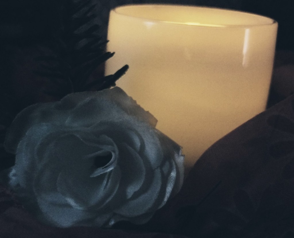 A candle holder and rose 